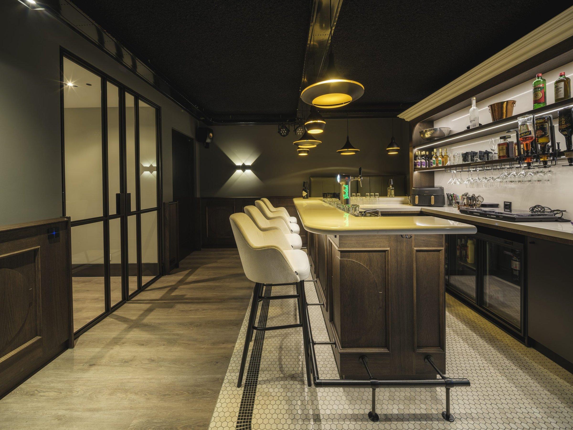 Bar met verlichte wandplanken en hanglampen