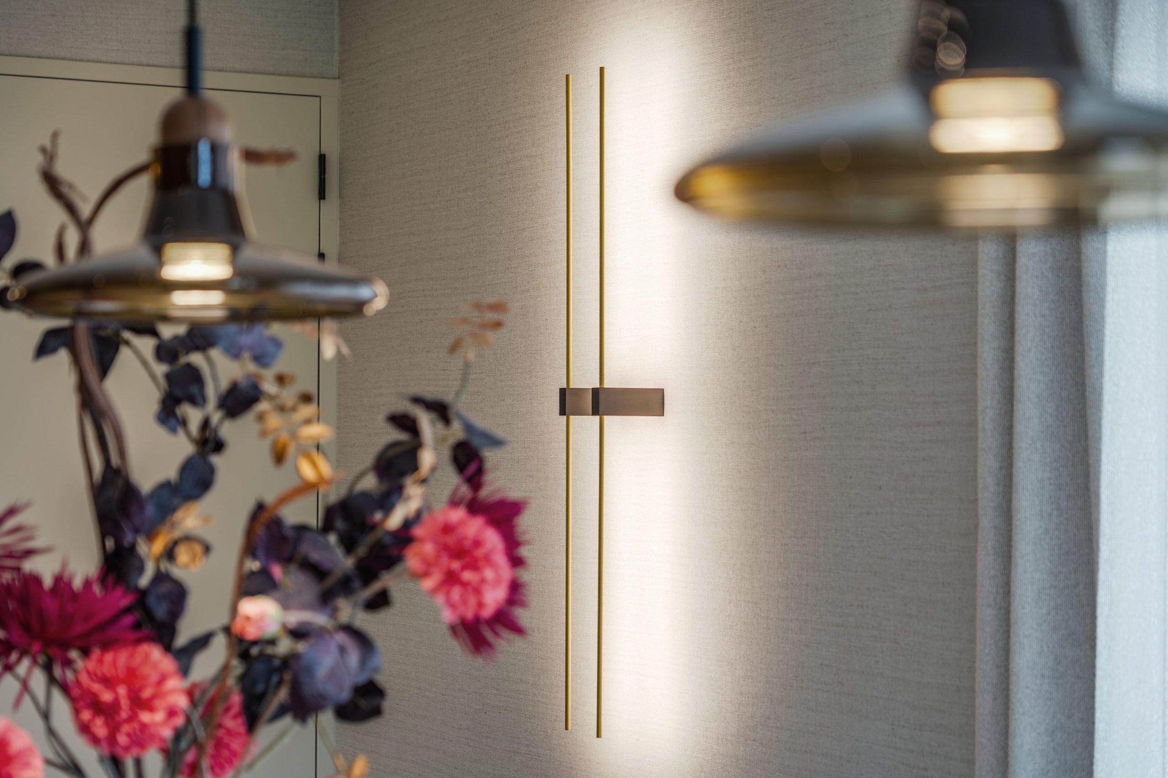 Wandlamp en hanglamp boven een boeket