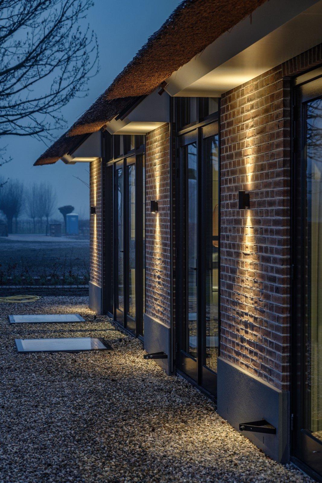Gevel met wandverlichting in de schemering