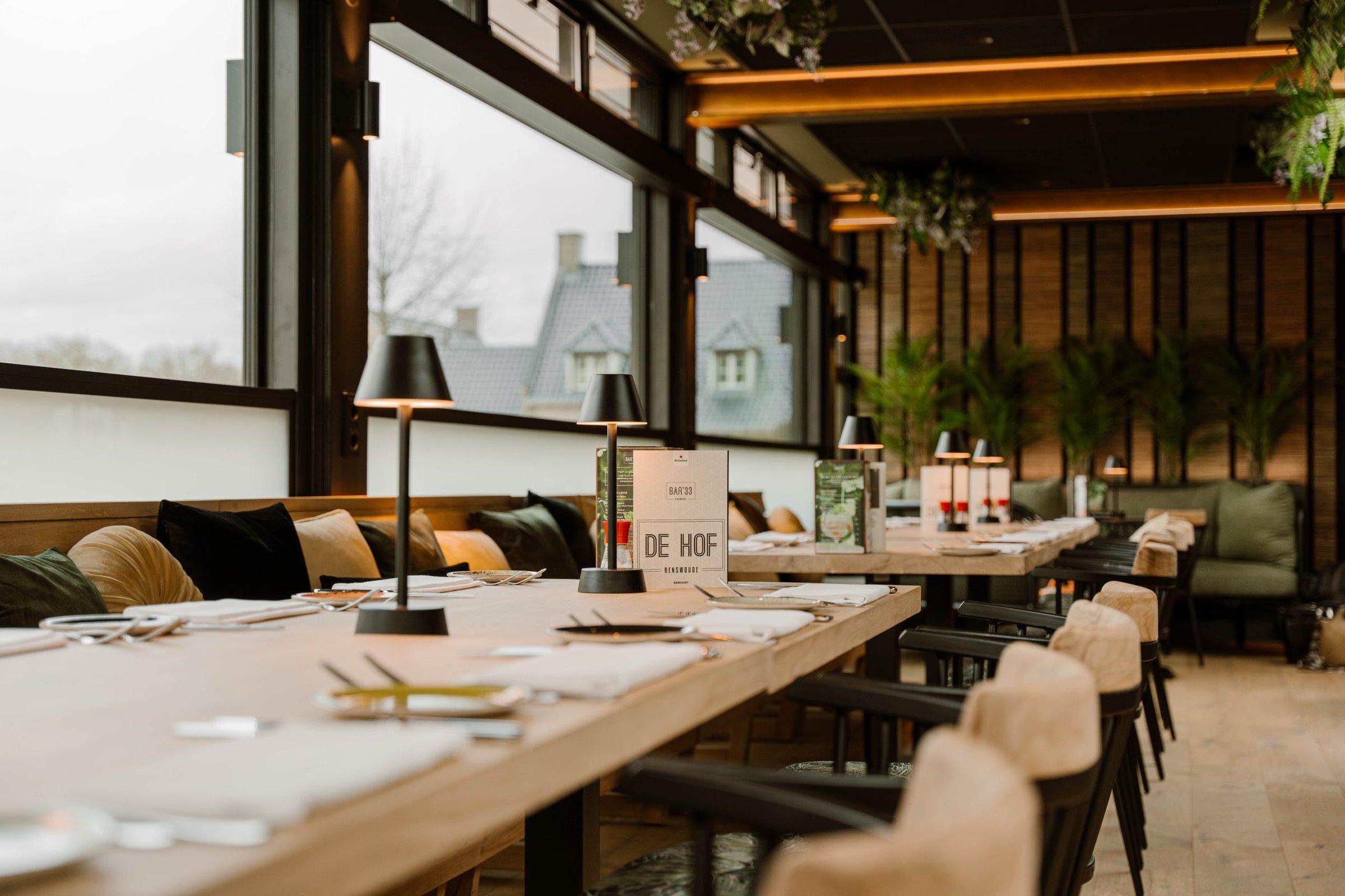 Lange tafel bij het raam met tafellampjes
