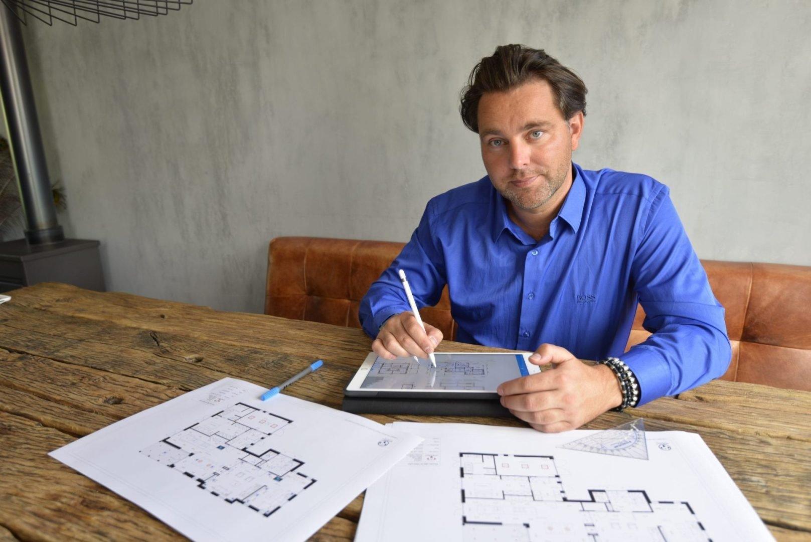 Ontwerper werkt aan een plattegrond met tablet